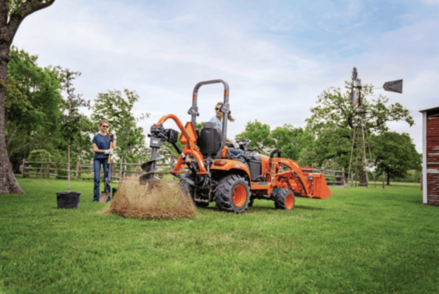 Woman using rear auger to make holes with tractor