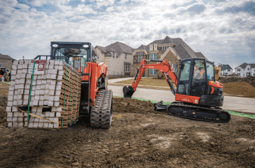 Track loader and excavator working on a construction site